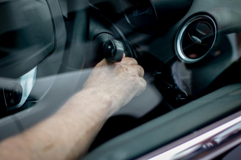 Close-up of a driver's hand starting the car ignition in Leeds, UK.